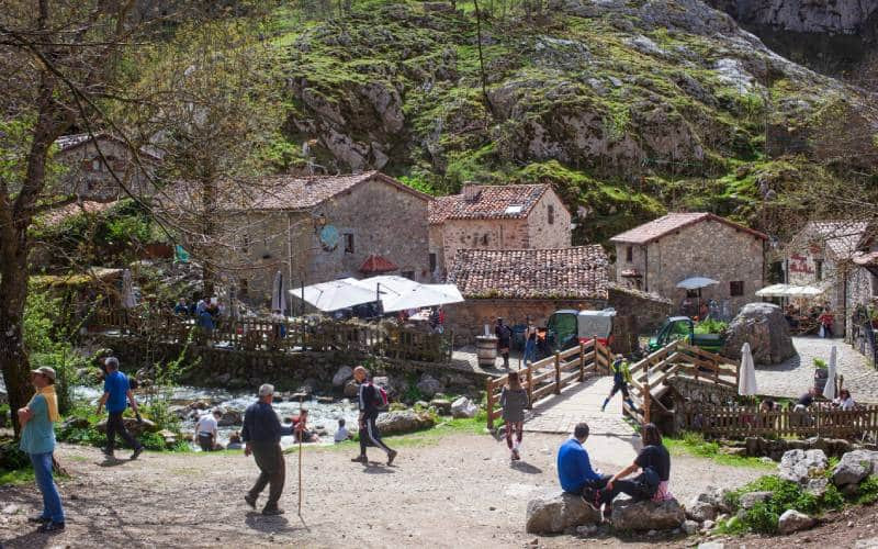 Chemin qui conduit à un hameau et touristes qui s'y promènent