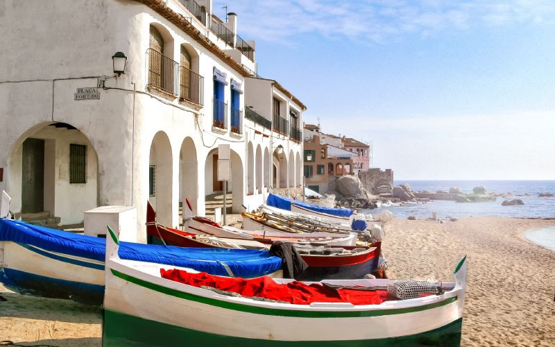 Barques sur une plage et maisons blanches àarcades