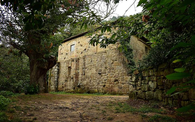 Mur du monastère de Santa Cristina s'élevant à travers les arbres