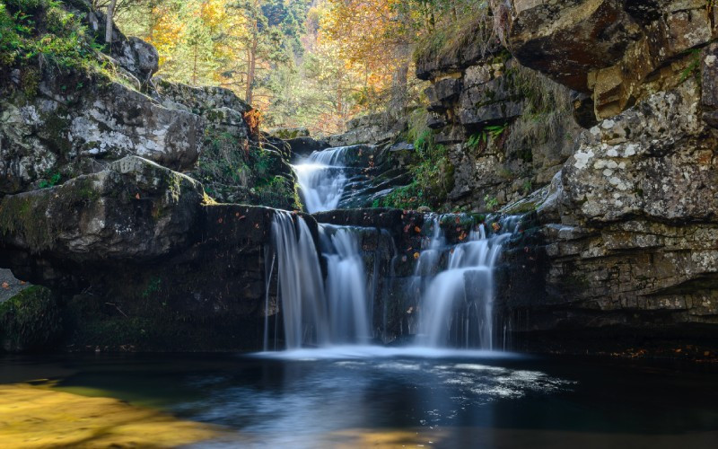 Cette chute d'eau au milieu des montagnes présente une image captivante