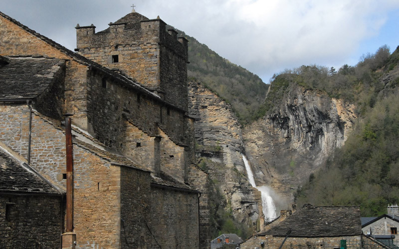 Église San Pedro et la chute d'eau en arrière-plan 