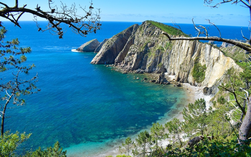 Une plage qui a une forme de coquille presque parfaite