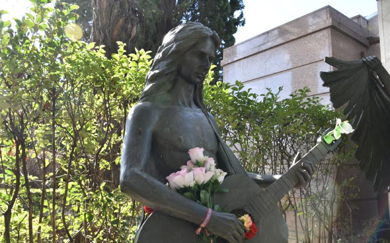 Sculpture d'Antonio Flores jouant de la guitare à côté du mausolée familial