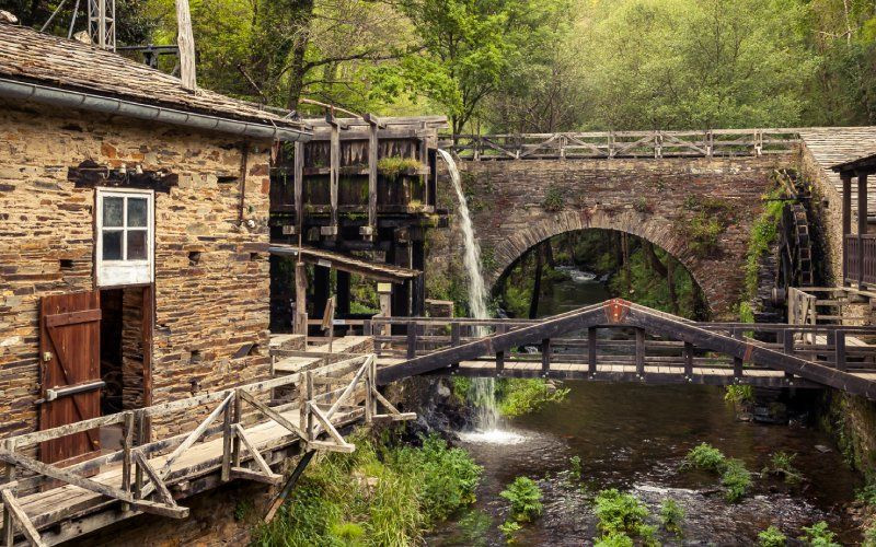 Un vieux moulin à eau au milieu de la montagne, entouré d'une végétation luxuriante, à Taramundi