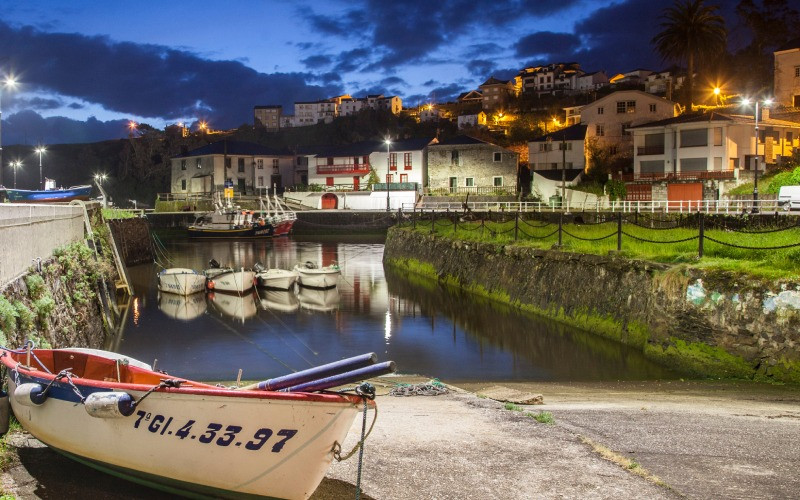 Vue de nuit du quai de Puerto de Vega, avec des bateaux