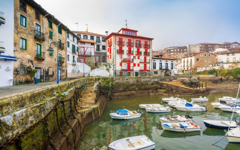 Port avec des barques et maisons aux volets colorés